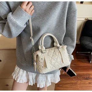 Vista dettagliata di una borsa trapuntata crema con strass indossata da una modella in casual