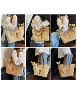 Detail view of large straw tote bags in beige and khaki with leather handles