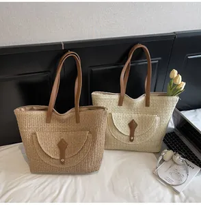 Close-up of woven straw tote bags with leather straps and metallic button closure