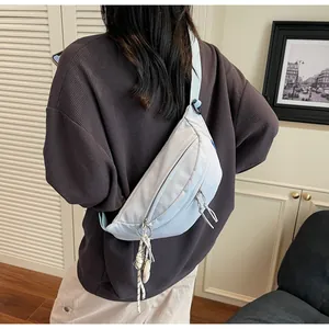 Detailed view of light blue crossbody bag with double zippers and adjustable strap
