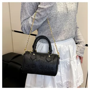 Détail du sac Boston noir avec gaufrage dessin animé et anneaux en métal doré élégants