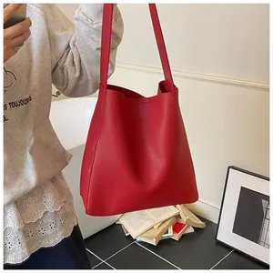 Dettaglio della borsa a secchiello rossa in pelle martellata con design spazioso