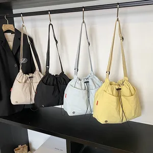 Grandi borse a secchiello in nylon impermeabile in quattro colori con coulisse e tracolla