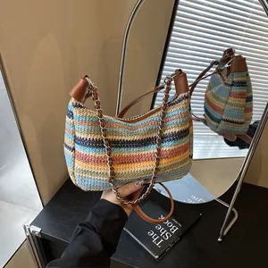 Rainbow striped woven straw tote bag with brown leather trim and metal chain strap