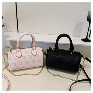 Détail des sacs Boston rose et noir avec motifs de dessins animés embossés et chaîne dorée