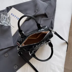 Elegante borsa trapuntata nera con strass argento e tracolla su blazer grigio