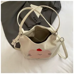 Detail of cream corduroy tote bag showing cute cat embroidery and adjustable shoulder strap