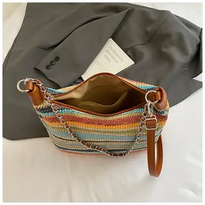 Rainbow striped straw tote bag with leather strap and chain detail seen from above