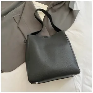Vista dettagliata della borsa tote in pelle nera con trama a grana e borchie d'argento