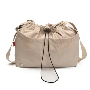 Grande borsa a secchiello in nylon beige con coulisse, trama a pieghe e tracolla