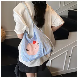 Close-up of blue checkered canvas tote bag featuring a cute pink cat patch detail
