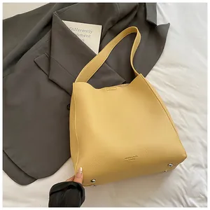 Dettaglio della borsa tote gialla in pelle martellata con scritta Fashion sul fondo