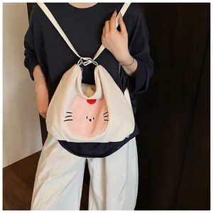 Close-up of cream corduroy tote bag with pink cat embroidery and slim shoulder strap