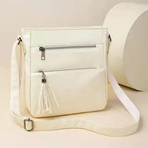 Borsa a tracolla vintage color crema con cerniere multiple e dettaglio nappina frontale