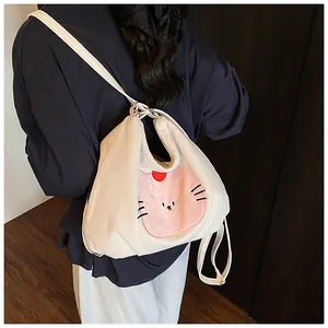 Close-up of white corduroy tote bag featuring a cute embroidered cartoon cat character