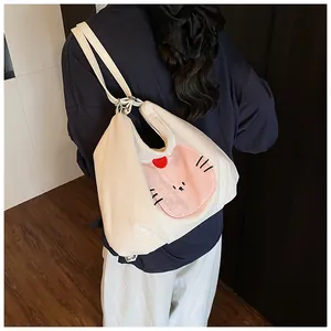 Close-up of white corduroy tote bag featuring pink cat face design and strap detail