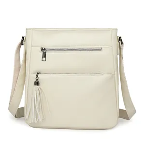 Borsa a tracolla verticale crema con cerniere multiple e nappa in pelle decorativa