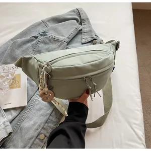 Detail of light green corduroy fanny pack with donut pendant on denim jacket background