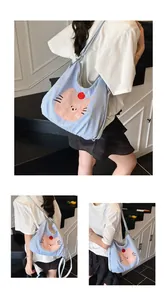Detail of blue gingham tote bag with cute cat patch and adjustable shoulder strap