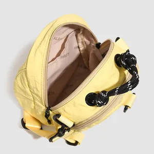Macro detail of pale yellow nylon shell bag with woven rope handle and inner lining