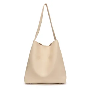 Borsa tote minimalista in pelle morbida beige con tracolla larga e piedini in metallo