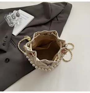 Macro shot of bucket bag interior featuring brown lining, inner pocket and pearl trim