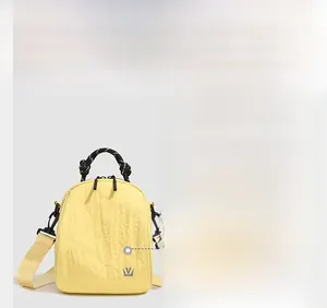 Close-up of waterproof crinkled nylon fabric on a pale yellow mini shell backpack