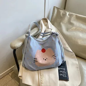 Blue plaid canvas tote bag with pink cartoon cat pattern and light blue leather straps