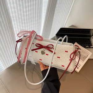 Sweet cream shoulder bag with red bows, polka dots, and a large heart pendant charm