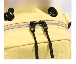 Macro shot of smooth dual metal zippers and yellow waterproof nylon fabric detail