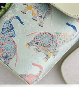 Detail of jacquard fabric small crossbody bag with ethnic elephant pattern and green trim