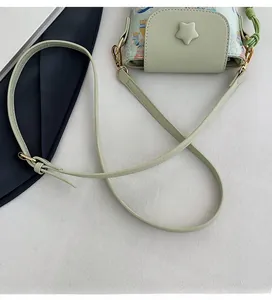 Detail of adjustable strap and star charm on mint green printed mini crossbody bag