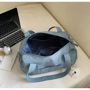 Internal view of blue nylon tote bag showing pockets, laptop, and plush dog charm