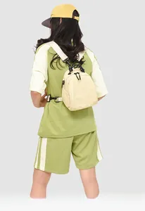 Detail of a cream mini backpack showing woven handle, double zippers, and soft pleated nylon