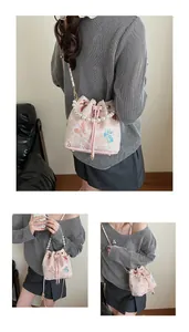 Detail of pink jacquard bucket bag showing pearl handle and butterfly pattern embroidery
