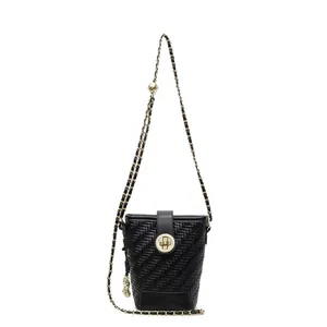 Sac seau tissé noir minimaliste avec bandoulière chaîne dorée et boule métallique