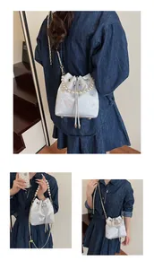 Detail of drawstring bucket bag featuring pearl handle and butterfly jacquard fabric