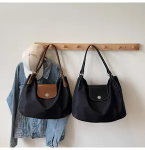 Close-up of large nylon tote bags with leather handles and silver snap button closure
