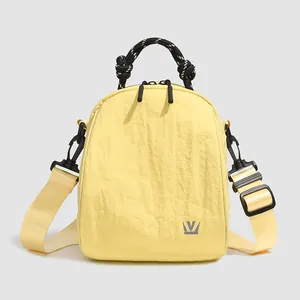 Light yellow mini nylon shell backpack with woven handle for casual outdoor use