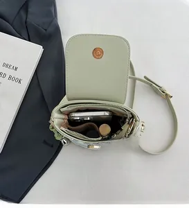Detailed interior of mini crossbody phone bag showing storage for smartphone and lipstick