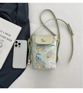 Detailed view of a mint green mini crossbody phone bag with painted elephant floral patterns