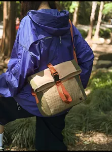 Detailed view of the outdoor messenger bag featuring durable mesh and orange strap