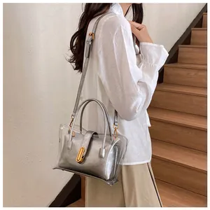 Detail of transparent PVC tote bag with silver inner pouch shown on a model