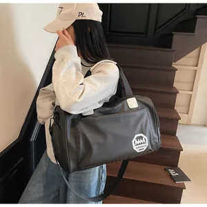 Dettaglio borsa da viaggio in nylon nero impermeabile con tracolla regolabile e manici