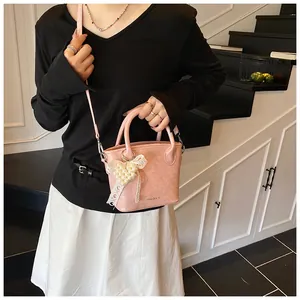 Detailansicht der rosa Beuteltasche mit Perlen-Herzanhänger und Spitze-Verzierung