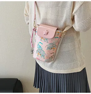 Detail of pink crossbody phone bag with elephant print and a star buckle on cover