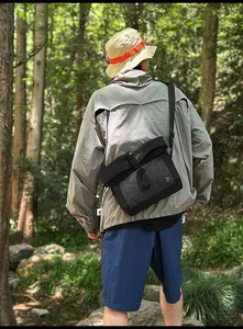 Outdoor crossbody bag in black fabric with white mesh detail and tactical buckles