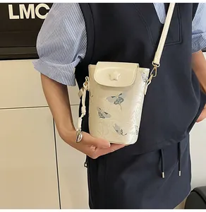 Detail of cream mini crossbody phone bag with blue butterfly print and star buckle