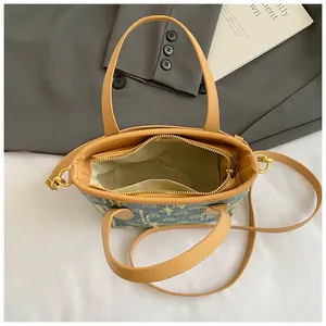 Dettaglio interno della borsa tote in denim jacquard con tasca e manici in pelle