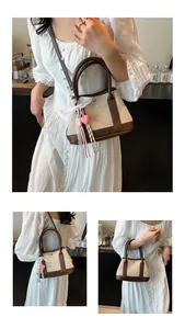 Detail of canvas handbag with brown leather trim, lace ribbon and pink heart pendant